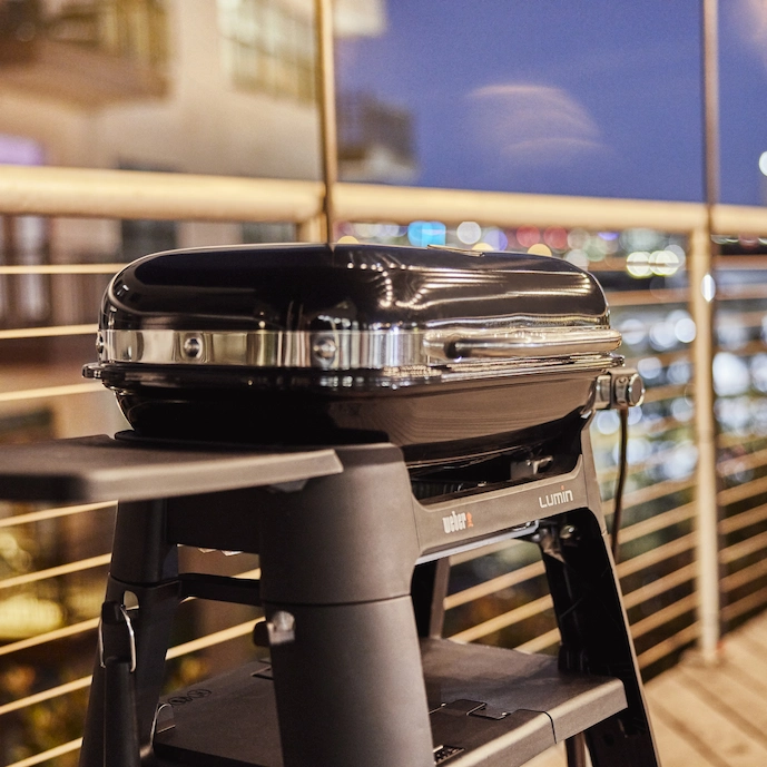 weber-lumin-elektrogrill-stand-auf-einem-balkon-am-abend